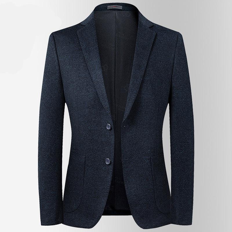 A charcoal gray wool blazer with two-button closure displayed against white background. Clean lines with notched lapel and flap pockets