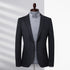 A charcoal wool blazer on mannequin with light gray button-down shirt. Shadow lighting highlights textured fabric with clean tailoring