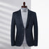 A charcoal blazer styled with gray button-down shirt on mannequin form. Natural light casting shadows across the elegant minimalist design