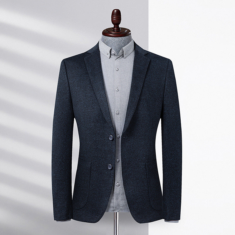 A charcoal blazer styled with gray button-down shirt on mannequin form. Natural light casting shadows across the elegant minimalist design