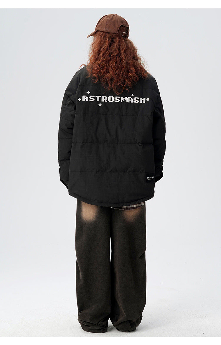 Back view of model showing ASTROSMASH logo across shoulder blades of black puffer jacket with brown wide-leg pants