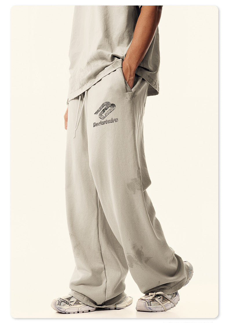 Side view of model's hip area showing pocket detail of cream Backstairs sweatpants with hand inserted, distressed fabric texture visible