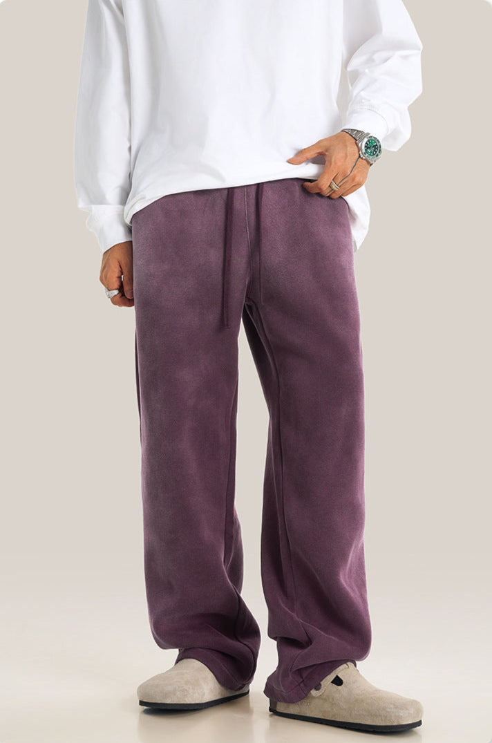 Person wearing purple sweatpants with white sweatshirt and beige sandals, showing casual comfortable styling