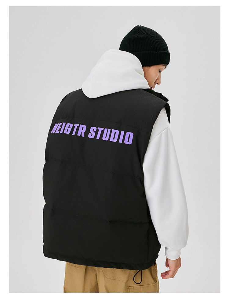 Back view of black puffer vest with purple NEIGTR STUDIO lettering worn over white hoodie with black beanie against white background