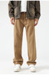 Khaki wide-leg trousers with relaxed fit, paired with brown jacket and white sneakers