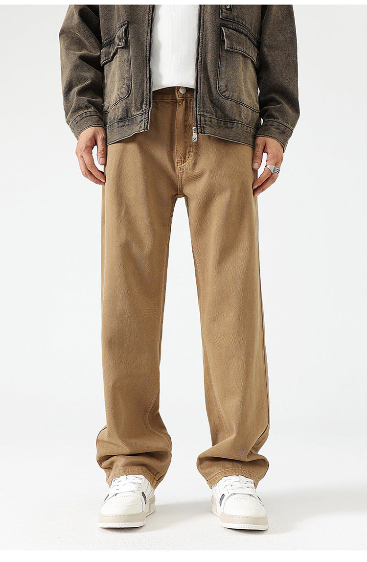 Khaki wide-leg trousers with relaxed fit, paired with brown jacket and white sneakers