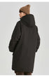 A woman in profile view wearing brown beanie and black NEIGHBORHOOD parka shows side silhouette against white background
