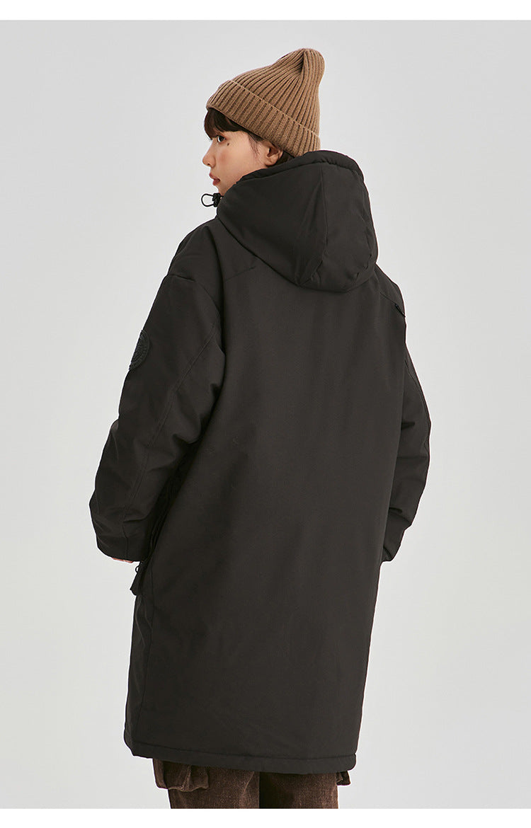 A woman in profile view wearing brown beanie and black NEIGHBORHOOD parka shows side silhouette against white background