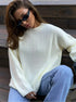 Woman in cream sweater and grey wide-leg pants, full-length fashion shot