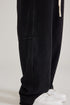 Detail shot of black sweatpants hem and paneling with white drawstring visible. Shown with white Air Force 1 sneakers