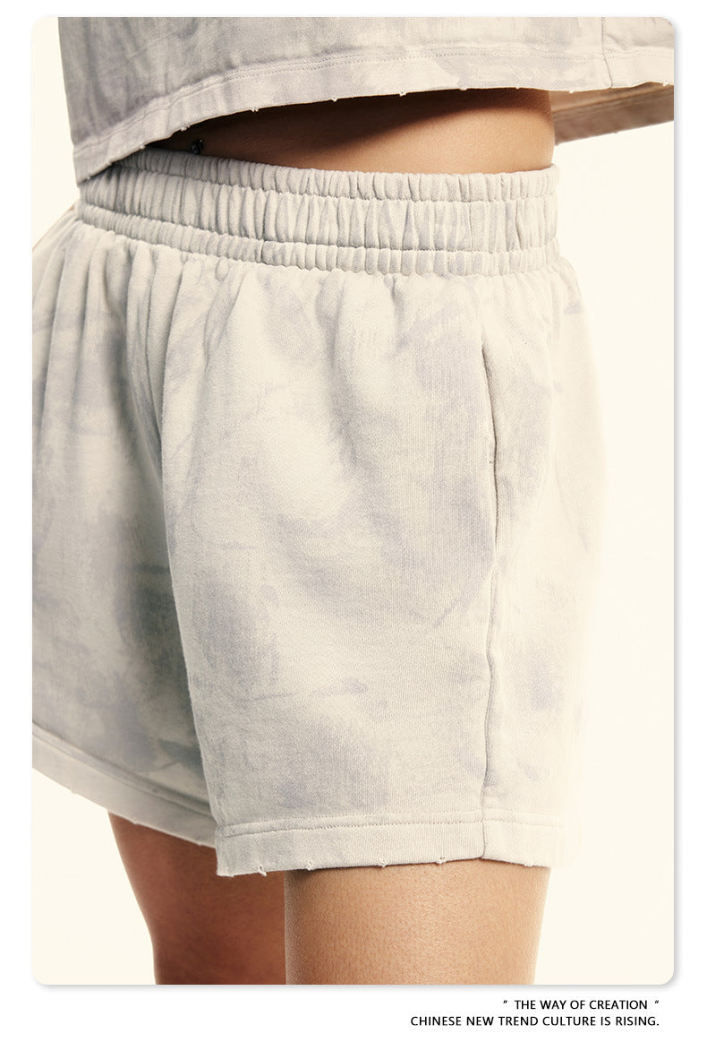 Close-up of light beige cotton shorts with elastic waistband showing side pocket detail