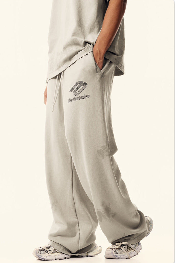 Side view of model in beige Backstairs sweatpants showing relaxed fit and pocket detail
