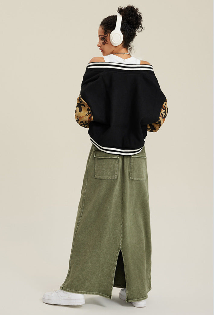 Back view of black varsity jacket with tan camouflage sleeves and white stripe detailing