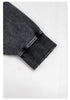 Close-up detail of black sweatshirt sleeve showing ribbed cuff construction