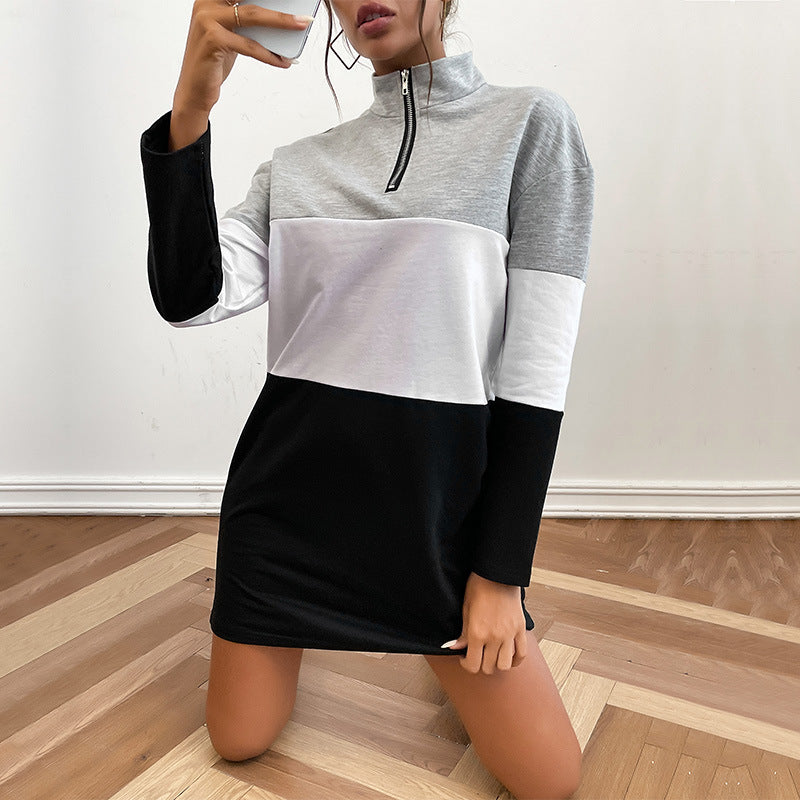 Color-block sweatshirt dress, kneeling pose, white sneakers, wooden floor