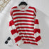 Red and white striped knit sweater on hanger against white background