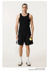 Model in black tank top and shorts holding a tennis racket and ball