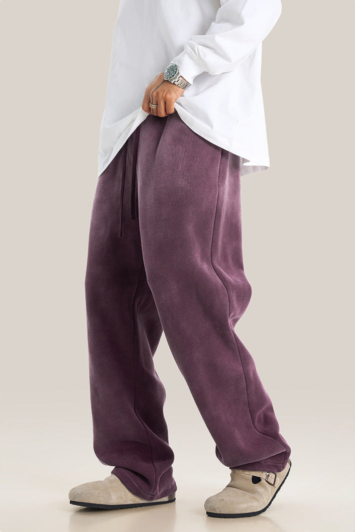 Side view of purple sweatpants with drawstring waist paired with oversized white sweatshirt
