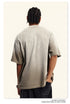 Back view of beige Breaking Tradition tee showing oversized fit and premium cotton construction