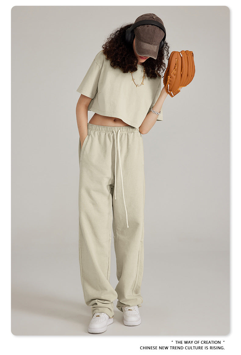 Close-up of dark charcoal sweatpants with white drawstring, showing fabric texture and side pocket detail