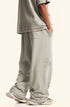 Profile view of beige sweatpants showing loose fit and textured fabric