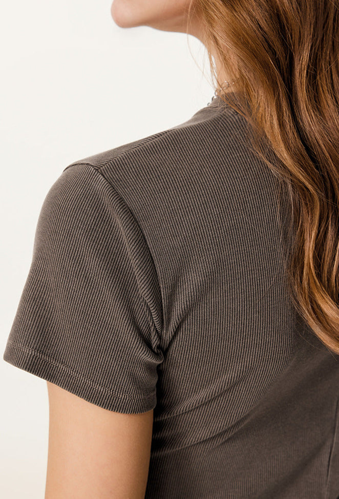 A rear angle of a model in a brown sleeveless maxi dress, showcasing the streamlined silhouette.
