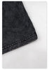 Detail of black garment's bottom hem showing distressed fabric texture