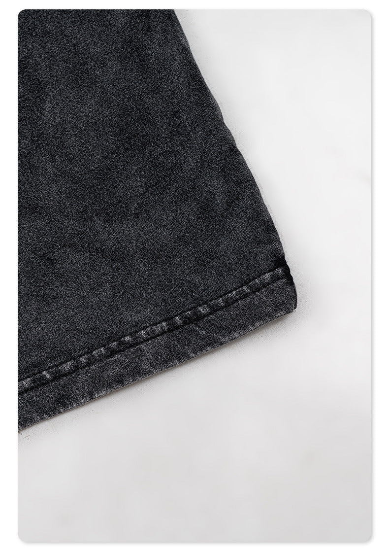 Detail of black garment's bottom hem showing distressed fabric texture