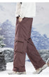 Profile shot of brown cargo pants showing movement and pocket detail, paired with outdoor sneakers