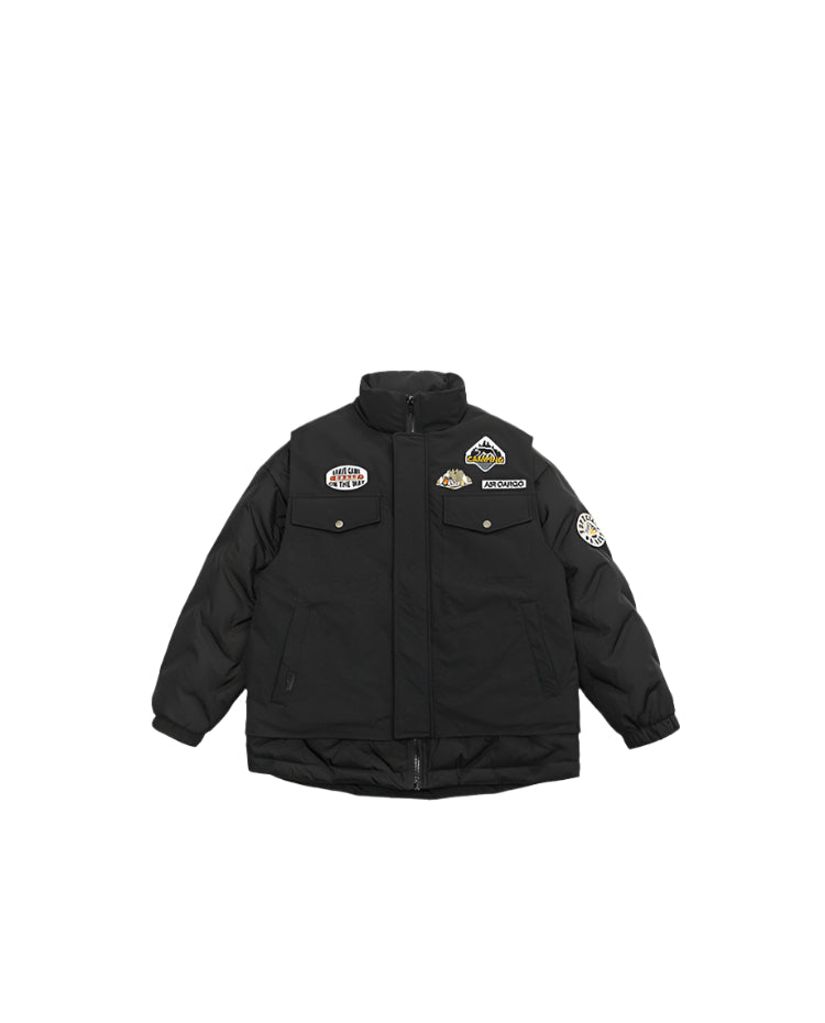 Flat lay of black padded winter jacket with multiple adventure-themed patches and utility pockets