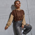 Brown hoodie, white sunglasses, braided hair, ripped jeans, industrial concrete setting