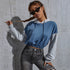 Cropped blue hoodie, braided model, black sunglasses, ripped gray jeans against concrete wall