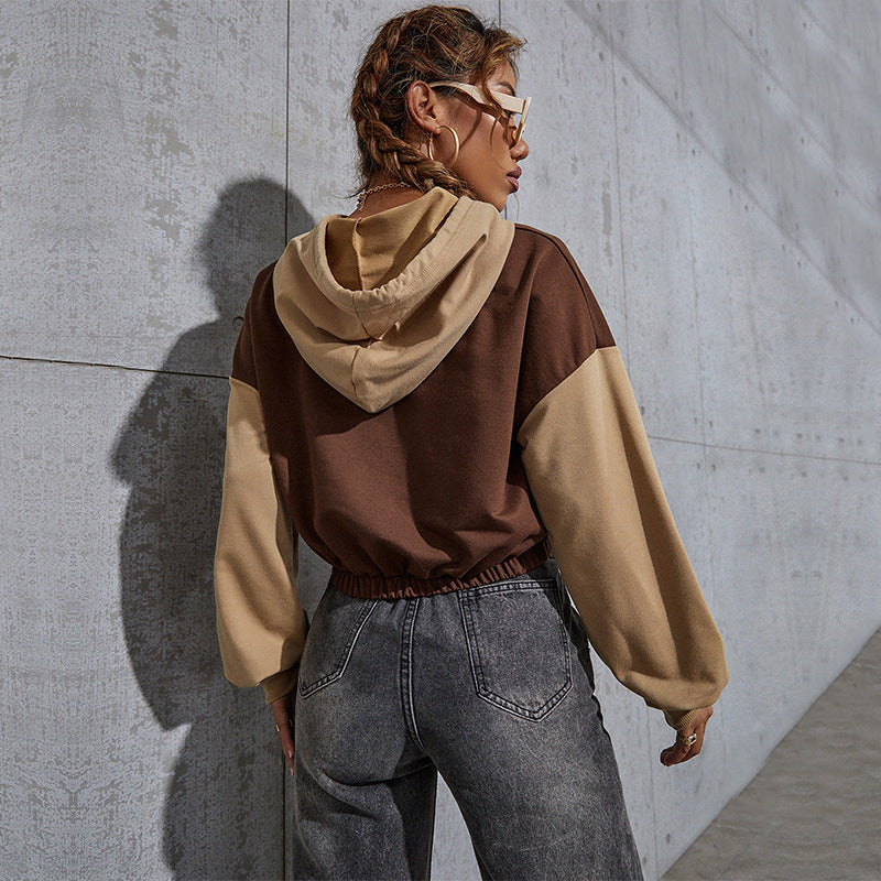 Brown two-tone hoodie, model's back, black sunglasses, distressed jeans, concrete backdrop