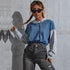 Blue-gray cropped hoodie, cat-eye sunglasses, braided model, textured wall background