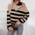 Beige and black striped sweater with off-shoulder design, styled with jeans and chain strap bag