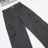 Side view of charcoal cargo pants showing utility pockets and curved panel stitching detail on white surface