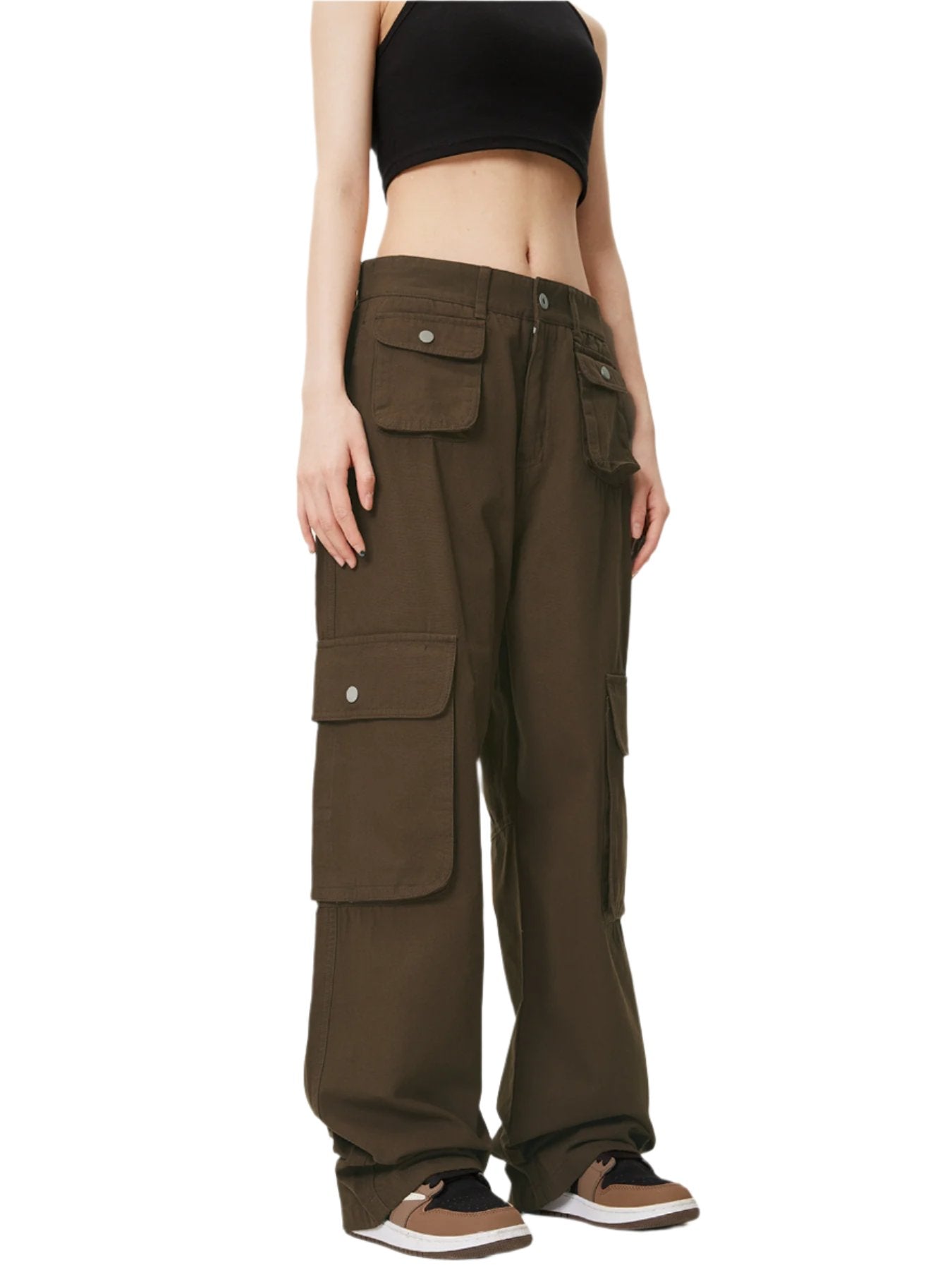 A model is wearing dark olive green cargo pants with multiple flap pockets and a black crop top, standing against a white background