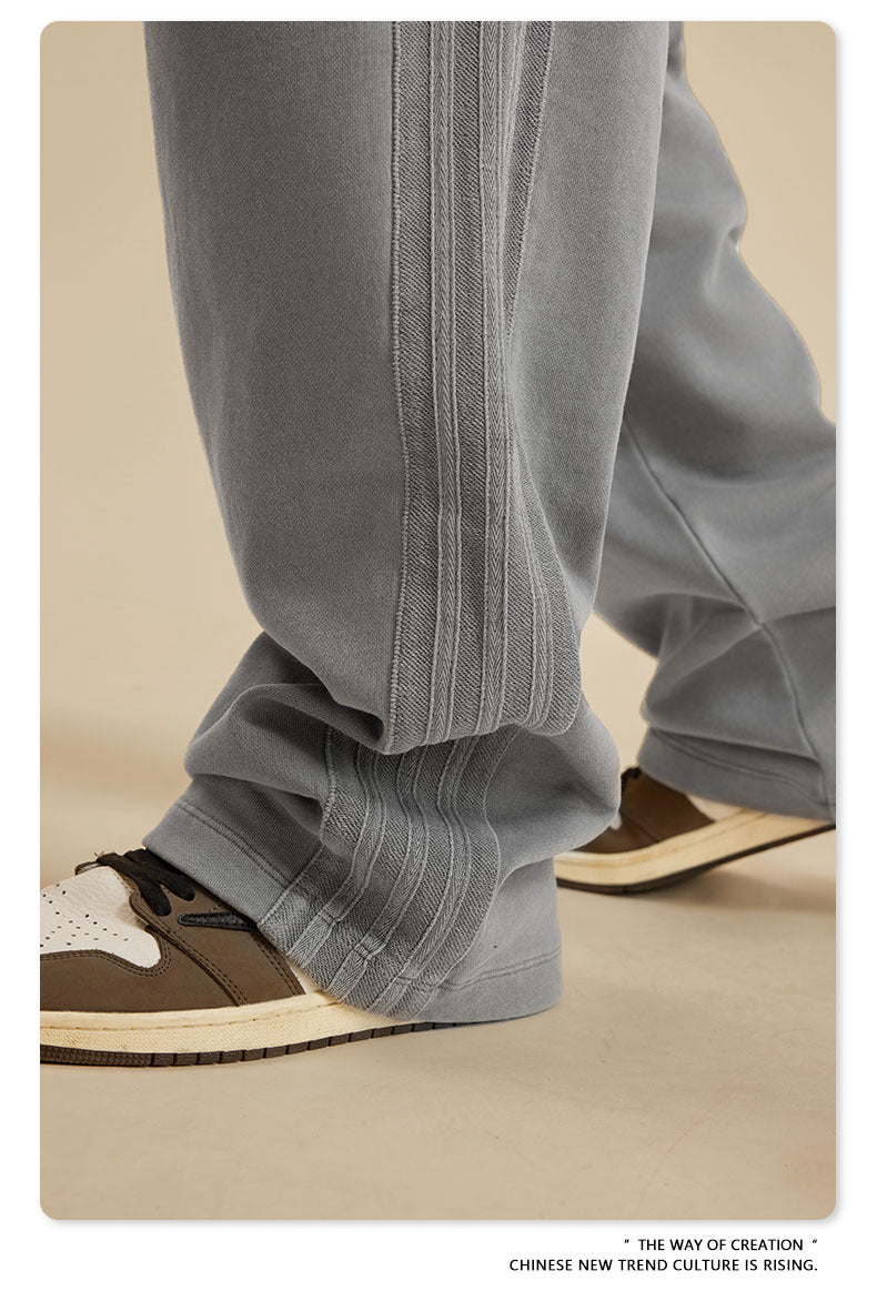 Close-up of grey sweatpants leg showing textured side panel detailing