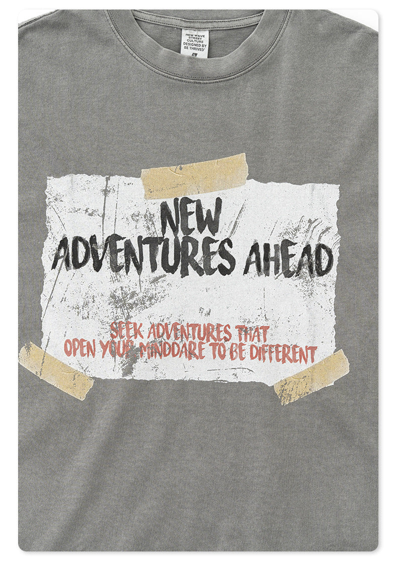 Detail of gray t-shirt with "New Adventures Ahead" motivational text graphic against washed fabric