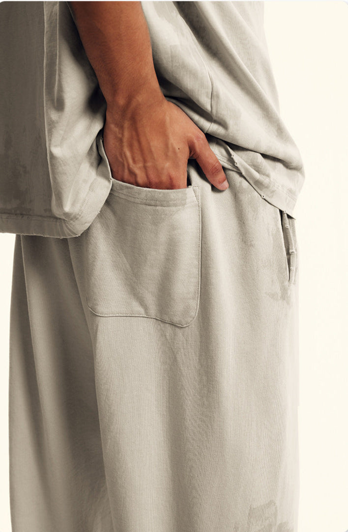 Close-up of hand in pocket of beige sweatpants showing construction details