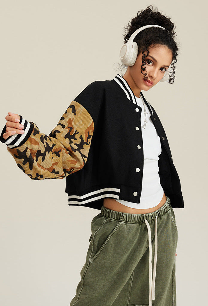 Black varsity jacket with tan camouflage sleeves, viewed from back angle, showing cropped silhouette