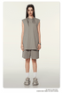 Model wearing sage green matching set with sleeveless top and shorts, white socks, chunky sneakers, and silver chain necklace on neutral background