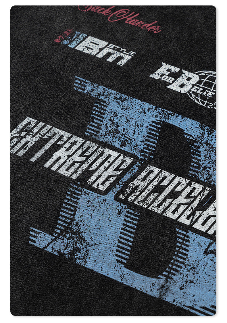 Detailed view of black t-shirt fabric showing distressed blue and white 'Extreme Acceleration' graphic print texture