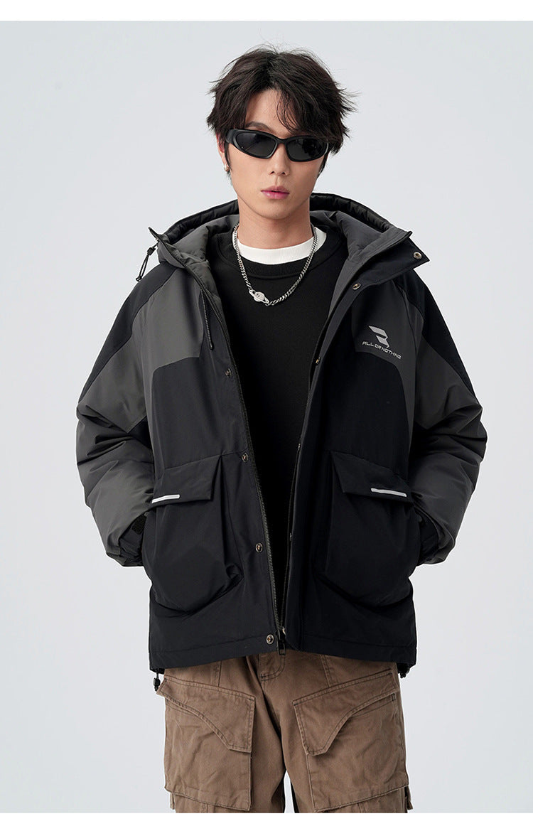 A man in black sunglasses and silver chain necklace models black/gray All Drifting jacket with tan cargo pants against white background