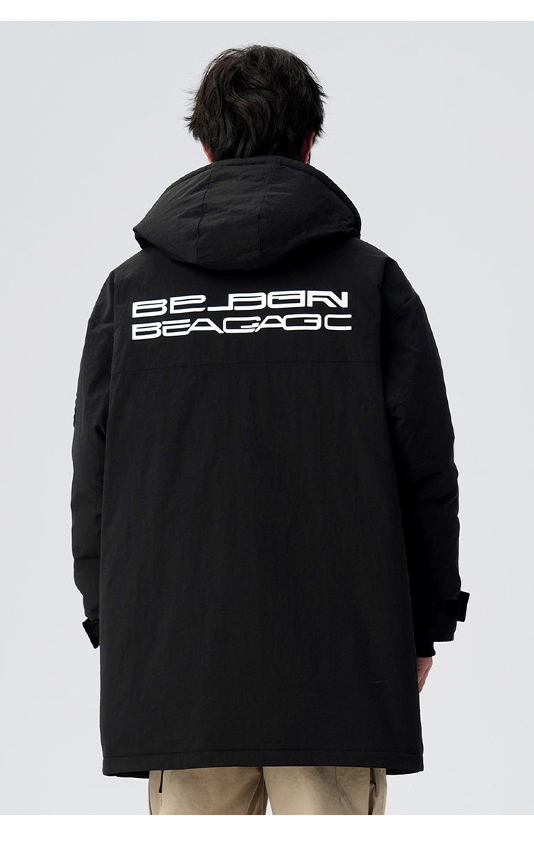 Back view of man wearing black Be_Born Beacaac parka showing white logo text and beige pants against white background