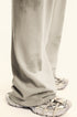 Detail shot of beige sweatpants fabric showing distressed print effect