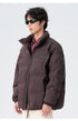 Male model demonstrating brown and black puffer jackets with various styling