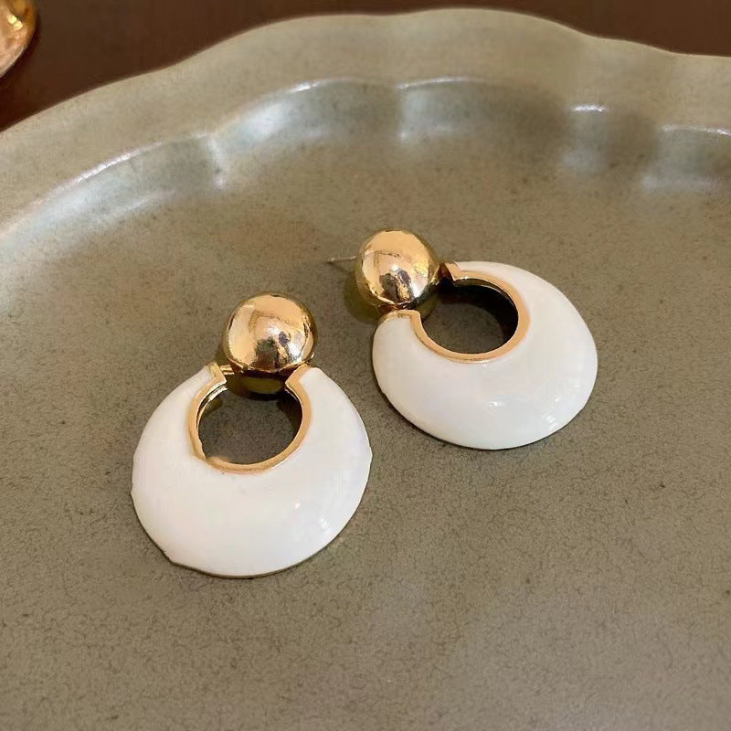 White and gold statement earrings with circular design, gold ball stud detail