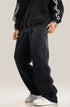 Model wearing black sweatpants with striped hoodie sleeve detail and white athletic shoes