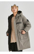 A man in olive NEIGHBORHOOD parka partially unzipped shows beige shirt underneath with beanie and plaid scarf against white background
